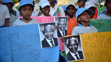 Des enfants sud-africains souhaitent un bon rétablissement à Nelson Mandela, le 15 juin 2013 à Johannesbourg [Mujahid Safodien / AFP]