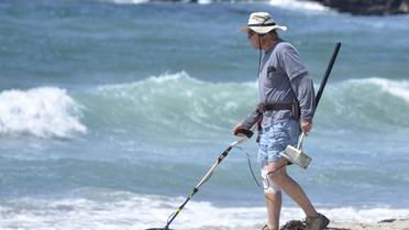 Un homme sur une plage de Californie avec un détecteur de métaux