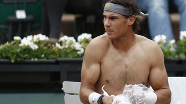 Rafael Nadal change de chemise lors d'un changement de côté lors de son match contre le Slovaque Martin Klizan, le 31 mai 2013 à Roland-Garros [Martin Bureau / AFP]