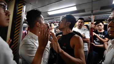 Des manifestants essaient de bloquer une rame de métro, le 5 août 2019 à Hong Kong [Anthony WALLACE / AFP]