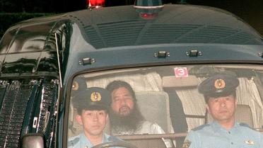 Sur cette photo du 19 juillet 1995, Shoko Asahara, gourou de la secte Aum, est conduit par la police à un tribunal de Tokyo [JIJI PRESS / JIJI PRESS/AFP/Archives]