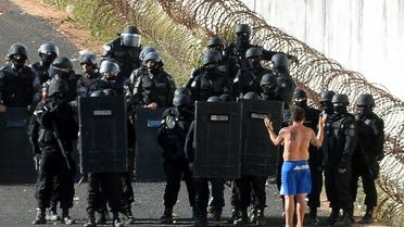 La police anti-émeute s'approche d'un homme choisi pour négocier au nom des détenus en rebélion au centre pénitentier d'Alcacuz dans l'Etat de Rio Grande do Norte dans le nord-est du Brésil, le 16 janvier 2017 [ANDRESSA ANHOLETE / AFP]