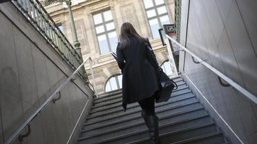 Une femme monte l'escalier d'une station de métro [Lionel Bonaventure / AFP]