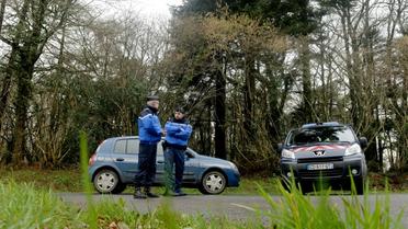 Les gendarmes ferment l'accès à la route où un pantalon et la carte vitale de Charlotte Troadec ont été retrouvés, le 1er mars 2017 à Dirinon dans le Finistère  [FRED TANNEAU / AFP]