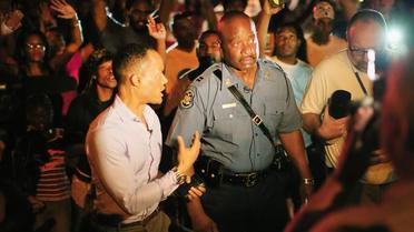 Le capitaine Ron Johnson chargé de ramener l'ordre à Ferguson marche parmi les manifestants, le 14 août 2014 dans cette petite ville du Missouri [Scott Olson / Getty Images North America/AFP]