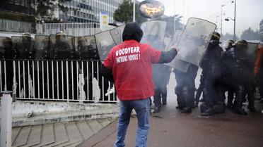 Un salarié de Goodyear face à des CRS devant le siège social à Rueil-Malmaison, le 7 mars 2013 [Lionel Bonaventure / AFP/Archives]