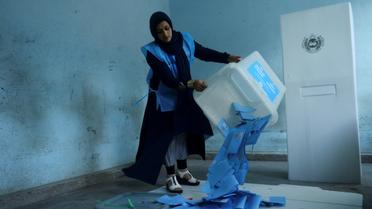 Une responsable de la commission électorale en Afghanistan vide une urne pour le comptage des voix après la fermeture des bureaux de vote pour l'élection présidentielle, le 28 septembre 2019 [HOSHANG HASHIMI / AFP]