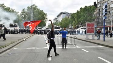 Un homme brandit un drapeau du parti socialiste belge lors d'une manifestation anti-austérité à Bruxelles le 24 mai 2016 [DIRK WAEM / Belga/AFP]
