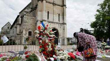 Un femme dépose des fleurs devant l'église de Saint-Etienne-du-Rouvray, le 29 juillet 2016 [CHARLY TRIBALLEAU / AFP/Archives]
