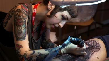 Une tatoueuse au travail lors du Mondial du tatouage, le 6 mars 2015 à Paris [JOEL SAGET / AFP/Archives]