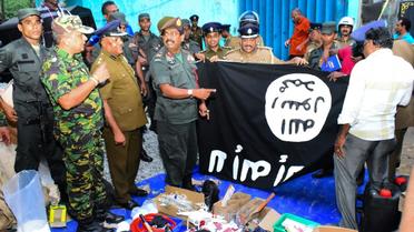 Les forces de l'ordre devant des objets saisis après l'assaut lancé contre une cache de jihadistes, à Kalmunai, au Sri Lanka, le 26 avril 2019 [STRINGER / AFP]