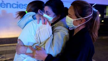Accolade entre infirmières en Espagne, à l'hôpital de La Fe à Valence le 26 mars 2020 [JOSE JORDAN / AFP]