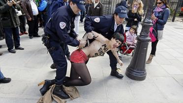 Une militante du groupe Femen arrêtée sur le parvis de Notre-Dame de Paris après une action dans la cathédrale, le 22 mai 2013 [Kenzo Tribouillard / AFP/Archives]