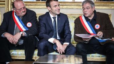 Emmanuel Macron avec Vanik Berberian (D), président de l'Association des maires ruraux de France et le secrétaire général Michel Fournier (G), le 14 janvier 2019 à Paris [Ludovic MARIN / POOL/AFP]