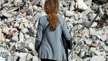 Une femme devant les décombres d'un immeuble détruit par le séisme à Amatrice, le 26 août 2016 [ANDREAS SOLARO                       / AFP]