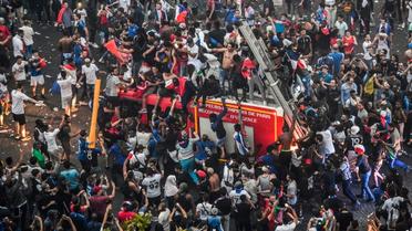Un camion de pompiers pris d'assaut par des supporters en liesse après le succès de la France en finale du Mondial, le 15 juillet 2018 sur les Champs-Elysées  [GERARD JULIEN / AFP]