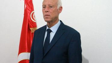 Le candidat indépendant à la présidentielle Kais Saied pose devant le drapeau tunisien, le 15 septembre 2019 à Tunis [MOHAMED KHALIL / AFP]