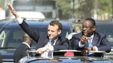 Emmanuel Macron, au côté du président sénégalais Macky Sall, salue la foule lors de sa visite à Dakar le 2 février 2018 [LUDOVIC MARIN / AFP]