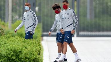 Les joueurs du Bayern Munich Thiago Alcantara, Alvaro Odriozola et Lucas Hernandez portent un masque à leur arrivée à l'entraînement le 13 mai à Munich [Christof STACHE / AFP]