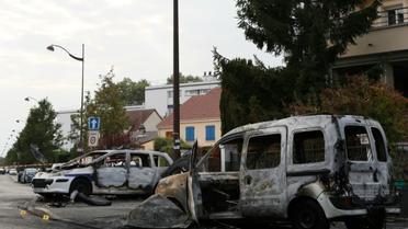 Une fougonette et un véhicule de police brûlés à Viry-Chatillon (Essonne) le 8 octobre 2016 par des agresseurs qui ont blessé deux policiers en patrouille [Thomas SAMSON / AFP/Archives]