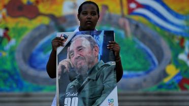 Une femme tient un portrait de Fidel Castro, en hommage au père de la Révlution cubaine au lendemain de sa mort, le 26 novembre 2016 à La Havane [Yamil LAGE / AFP]
