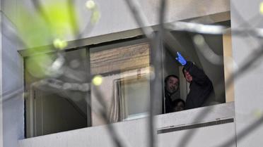 Un enquêteur de la police à la fenêtre de la résidence du général Odlanier Mena, le 28 septembre 2013 à Santiago [Martin Bernetti / AFP]