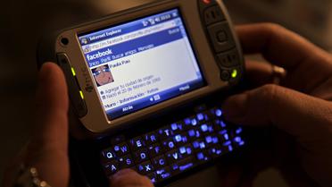 Une femme se connecte sur une page internet avec son téléphone portable [Juan Mabromata / AFP/Archives]