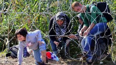 Des migrants passent la frontière au niveau du village hongrois de Röszke pour entrer en Serbie, le 28 août 2015  [Attila Kisbenedek / AFP/Archives]