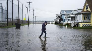 Une femme traverse une rue inondée à Ocean City, dans le Maryland, le 3 octobre 2015 [JIM WATSON / AFP]