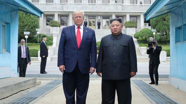 Photo fournie le 1er juillet 2019 par l'agence nord-coréenne Kcna du dirigeant nord-coréen Kim Jong Un (d) et le président américain Donald Trump se tenant au nord de la ligne de démarcation entre les deux Corées,  le 30 juin 2019 à Panmunjom [KCNA VIA KNS / KCNA VIA KNS/AFP]