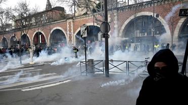 Des manifestants dans des nuages de gaz  lacrymogène lors de la manifestation parisienne contre la réforme des retraites, le 11 janvier 2020  [LIONEL BONAVENTURE / AFP]