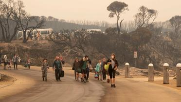 Des habitants marchent vers une plage avant d'être évacués de Mallacoota, en Australie, le 3 janvier 2020 [Helen FRANK / ROYAL AUSTRALIAN NAVY/AFP]