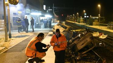 Des agents SNCF et la police près de voitures calcinées sur les voies ferrées devant la gare de Moirans, le 20 octobre 2015 [PHILIPPE DESMAZES / AFP]