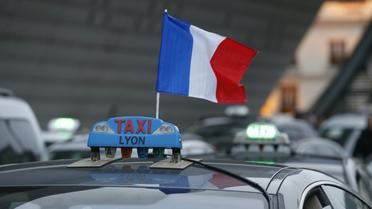 Un drapeau tricolore sur un taxi dont le chauffeur manifeste le 26 janvier 2016 à Paris [THOMAS SAMSON / AFP]