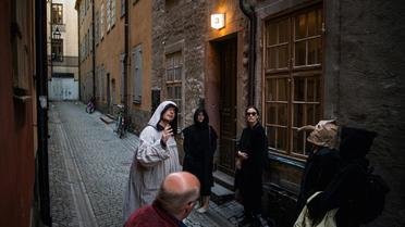 Le guide Mike Anderson, en costume, promène les visiteurs dans une "marche contre la peste", le 30 mai 2020 à Stockholm, racontant les grandes épidémies du passé [Jonathan NACKSTRAND / AFP]