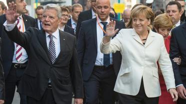 La Chancelière allemande Angela Merkel et le président Joachim Gauck saluent la foule, le 3 octobre 2015 à Francfort, à l'occasion des 25 ans de la Réunification de l'Allemagne [BORIS ROESSLER / POOL/AFP]