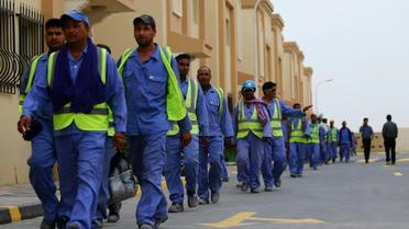 Des travailleurs immigrés de retour d'un site de construction du Mondial 2022 au Qatar, le 4 mai 2015 à Doha [Marwan NAAMANI, Marwan NAAMANI / AFP/Archives]
