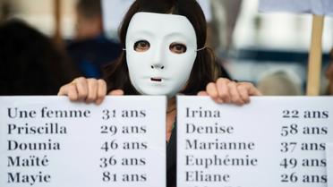 Une femme tient un panneau qui énumère les noms des victimes de féminicides en France pour les onze premiers mois de 2019, lors d'une manifestation à Marseille, le 23 novembre 2019 [CLEMENT MAHOUDEAU / AFP/Archives]