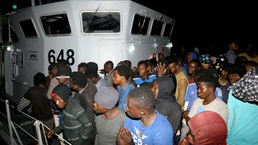 Des migrants arrivent à une base navale après avoir été secourus en mer, le 24 juin 2018 à Tripoli, en Libye [MAHMUD TURKIA / AFP]