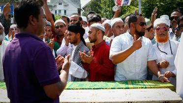 Des hommes prient autour des cercueils contenant les corps d'un imam et de son assistant tués par balles, à New York le 15 août 2016 [KENA BETANCUR / AFP]