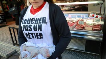 Une militante vegan devant une boucherie à Paris le 22 septembre 2018 [JACQUES DEMARTHON / AFP]