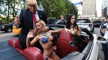 Un faux Donald Trump bien entouré, en route pour la Trump Tower de New York, le 25 octobre 2016 [TIMOTHY A. CLARY / AFP]