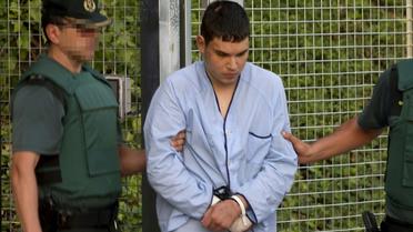 Mohamed Houli Chemlal, un Espagnol de 21 ans, membre présumé de la cellule jihadiste responsable des attentats en Catalogne, sort d'un centre de détention escorté par la guarde civile le 22 août 2017 à Tres Cantos, près de Madrid [STRINGER / AFP]