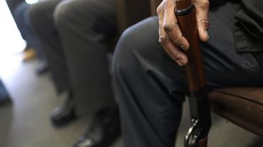 Photo d'illustration montrant un gros plan sur un homme attendant son tour pour rendre une arme lors d'une opération de reprise dans un commissariat de police américain en 2012 [Spencer Platt / Getty/AFP/Archives]
