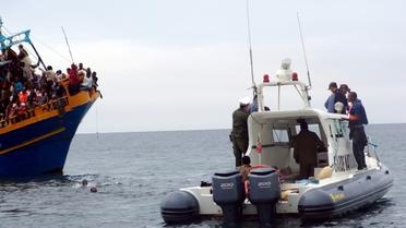 Des gardes-côtes tunisiens viennent en aide à des migrants en provenance de Lybie  au large de Sfax, le 4 juin 2011 [HAFIDH / AFP/Archives]