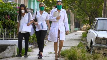 La docteure cubaine Liz Caballero (d) fait du porte-à-porte avec des étudiantes, en quête de nouveaux cas de coronavirus,le 31 mars 2020 à La Havane  [Adalberto ROQUE / AFP/Archives]