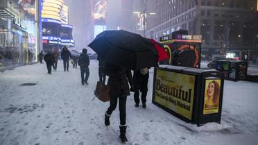 Des passants sur Times Square enneigé à Manhattan le 4 janvier 2018 [Jewel SAMAD / AFP]