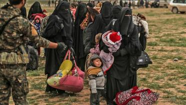 Un combattant des Forces démocratiques syriennes surveille des personnes évacuées du dernier réduit du groupe Etat islamique à Baghouz, dans l'est syrien, le 27 février 2019  [Delil SOULEIMAN / AFP]