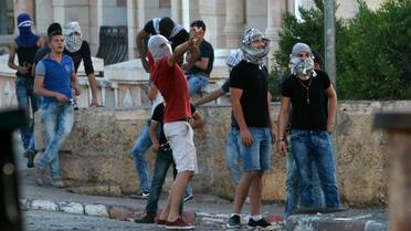 Des Palestiniens lancent des pierres sur les forces israéliennes de sécurité le 15 octobre 2015 à Bethlehem [MUSA AL-SHAER / AFP]