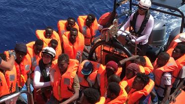 Des migrants secourus dans les eaux internationales au large de la Libye, à bord d'un bateau pneumatique appartenant au navire humanitaire Ocean Viking le 12 août 2019. L'Ocean Viking, affrété par SOS Méditerranée et Médecins sans frontières, a secouru lundi 105 migrants supplémentaires dans ces eaux, et compte désormais 356 personnes à bord. [Anne CHAON / AFP]